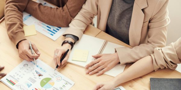 A diverse team of professionals collaborating over charts and graphs during a business meeting.